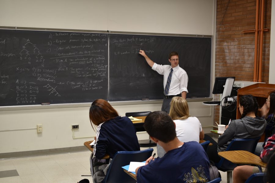 Instructor at chalkboard in front of classroom