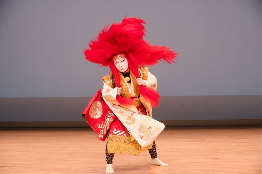 A kabuki actor onstage in a red and white costume
