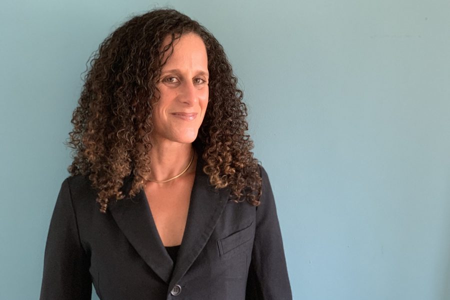 Sarah Abrevaya Stein smiles slightly in a landscape portrait against a blue background