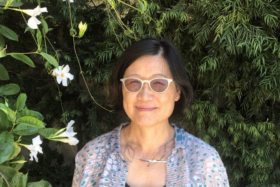 A portrait of Shu-mei Shih against a dark leafy background