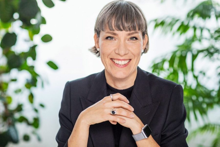 Darja Isaksson smiles at the camera with her hands clasped to her chest