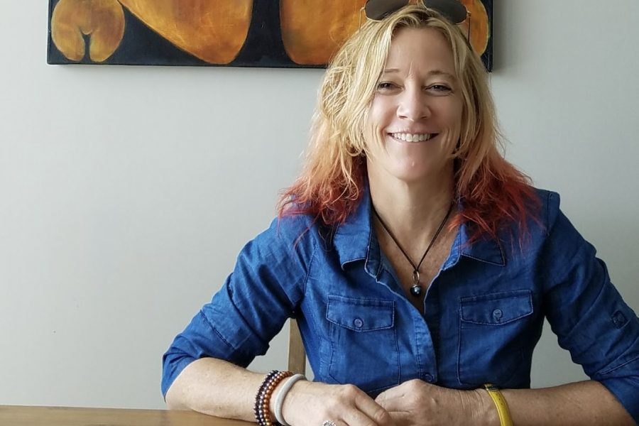 Portrait of Elizabeth DeLoughrey sitting at a table.