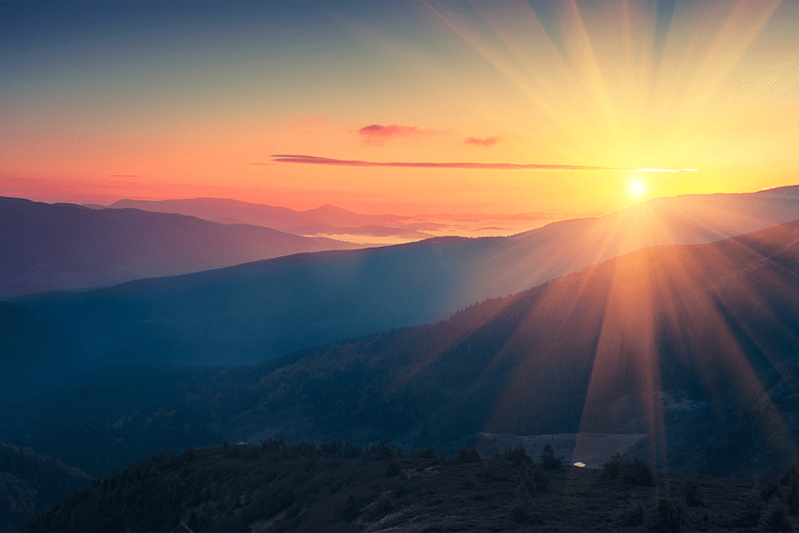 Sun setting over mountaintops