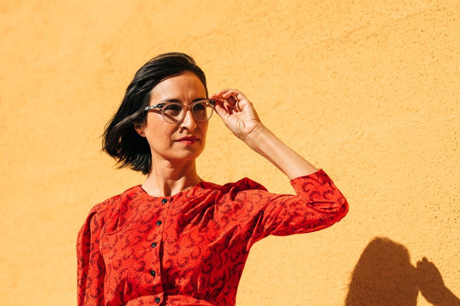 Portrait of Carribean Fragoza in a red top against a yellow background.