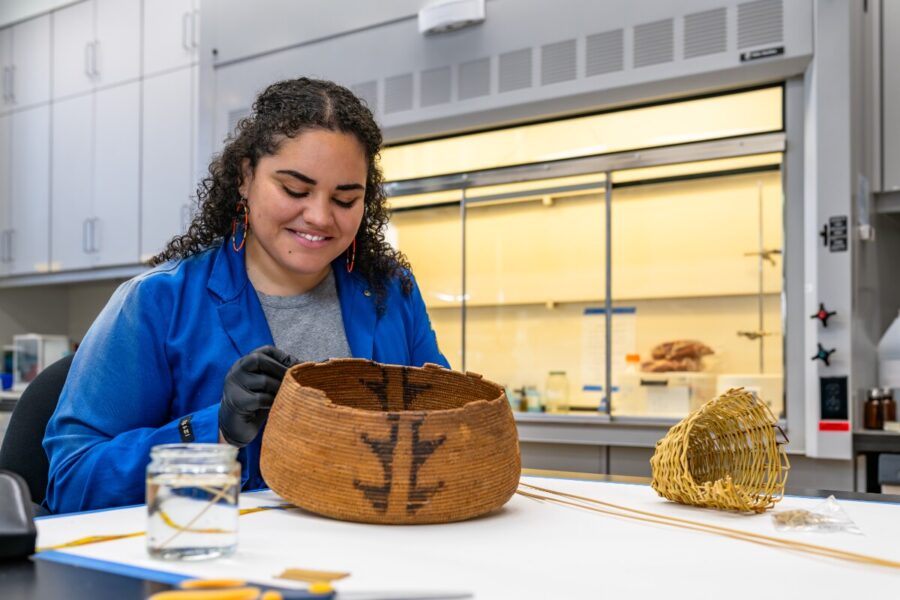 UCLA student Makayla Rawlins in conservation lab repairing a basket