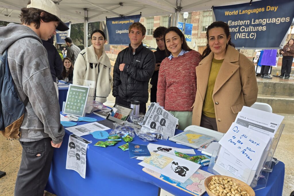 Volunteers with a visitor at the Near Eastern Languages and Cultures table at World Languages Day