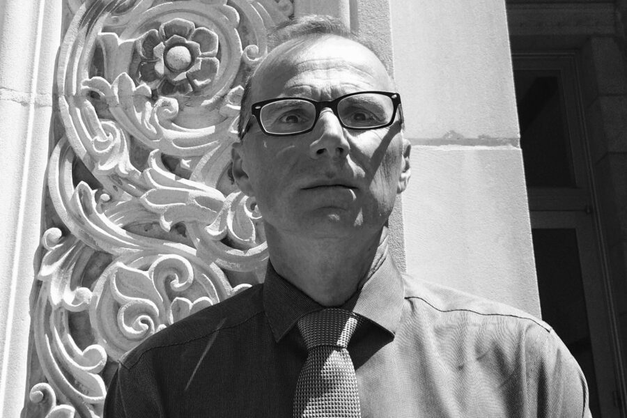 Black and white photo of Robert Gurval in front of a UCLA campus building