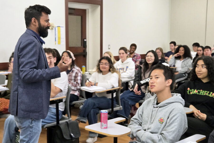 Professor Vetri Nathan, standing, with students seated and listening to his lecture