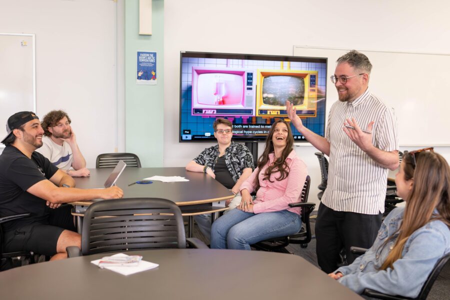 Danny Snelson, standing, center right, with four students seated in classroom