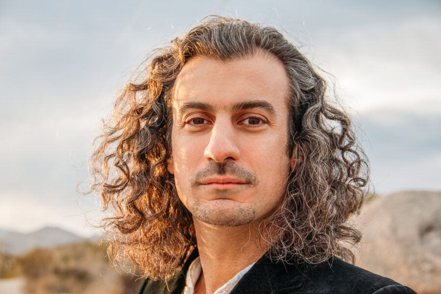 Portrait of Raffi Joe Wartanian outdoors with sky and mountains in background