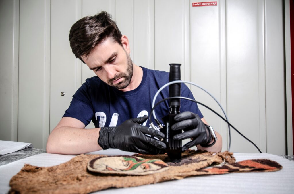 Thiago Puglieri analisa uma máscara do Museu de Arqueologia e Etnologia da Universidade de São Paulo