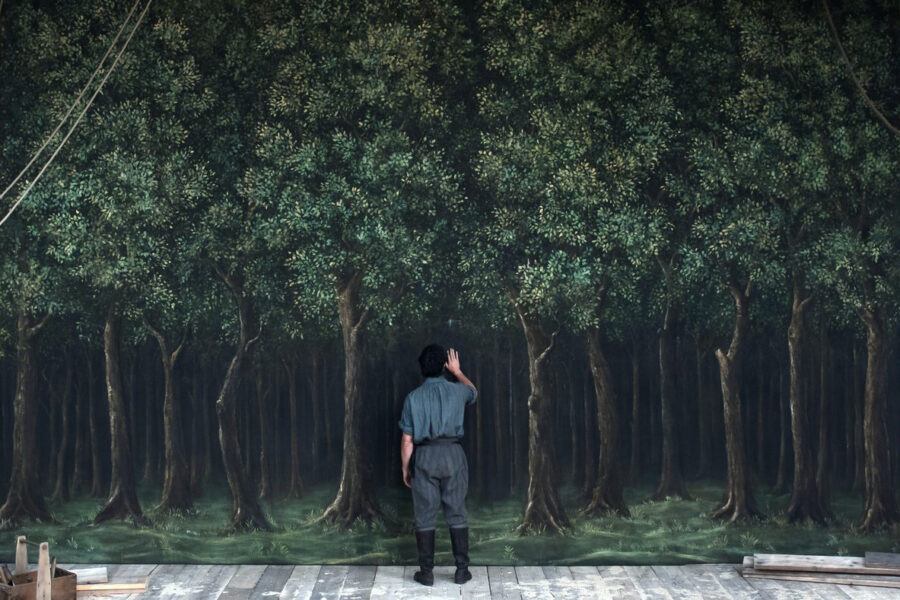 Image from Hamnet movie with Will character looking at backdrop of trees
