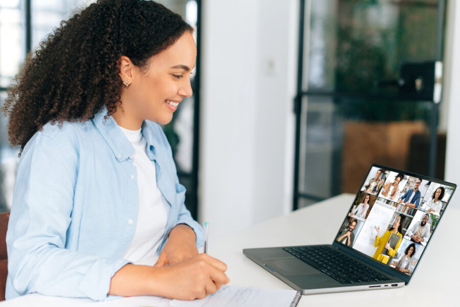 Student taking online class with teacher and other students visible on her laptop