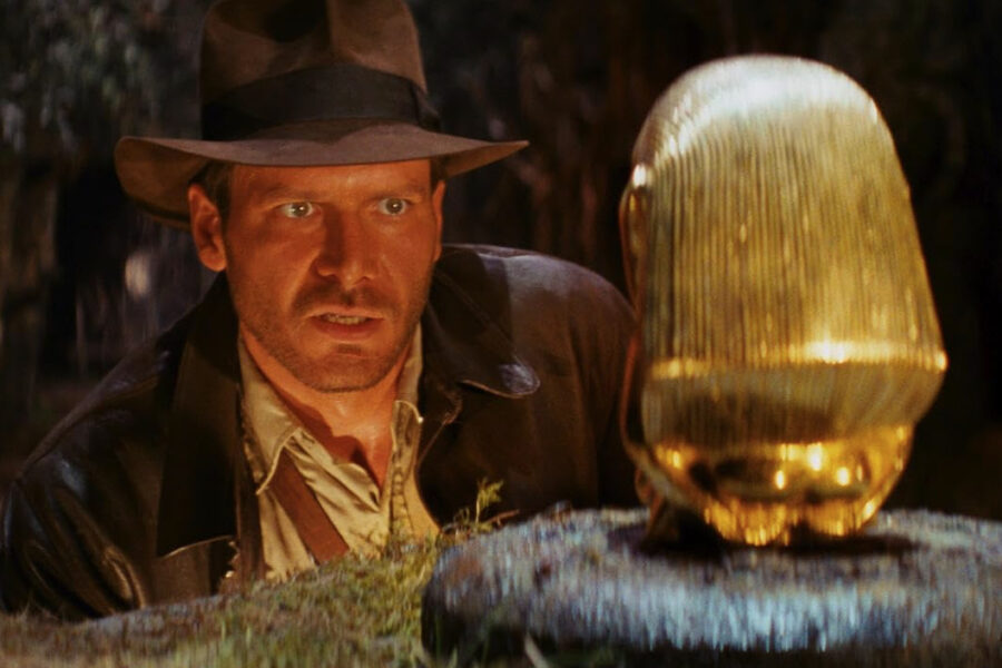 Harrison Ford as Indiana Jones looking at golden idol in still image from Raiders of the Lost Ark movie