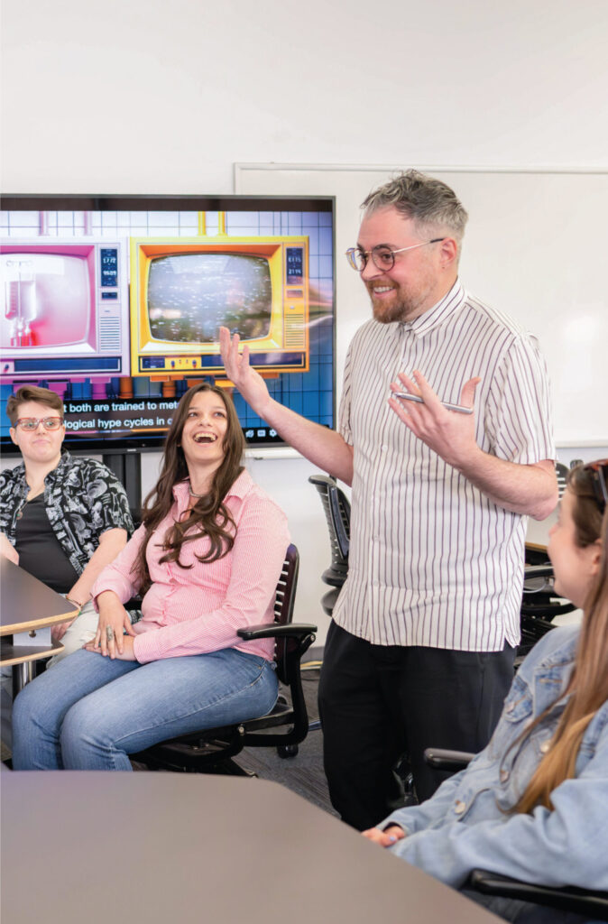 Professor in classroom with students smiling